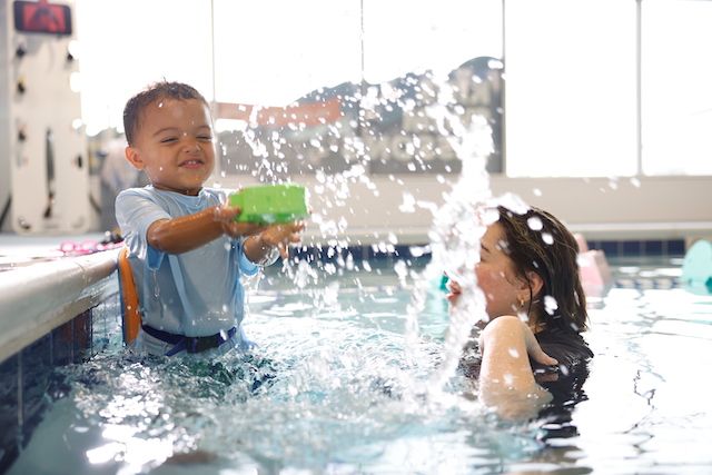 Boy playing at the pool conquering his fear of water