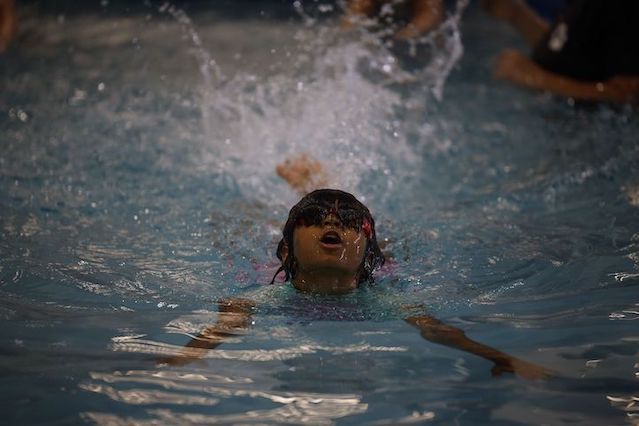 A young girl swims the butterfly