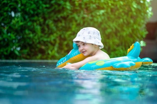 Little boy on a swimming pool float