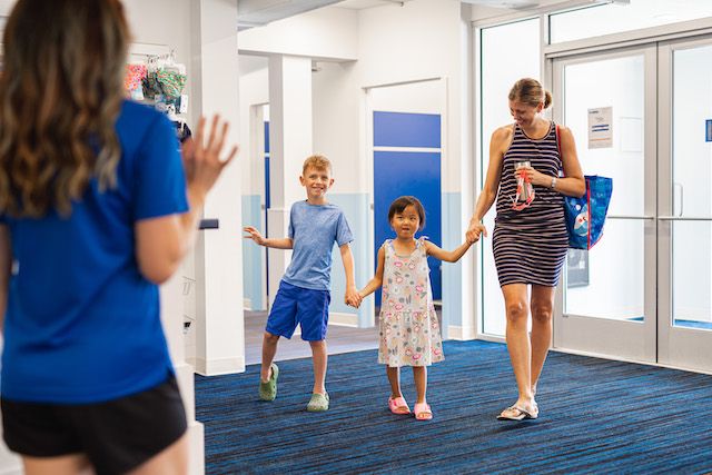 Family walks into Big Blue lobby, greeted by a staff member
