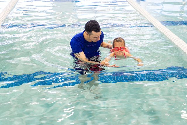Big Blue Swim School instructor teaching a swimming stroke to their student