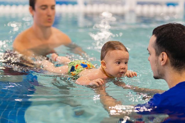 A baby wearing a swim diaper during swimming lessons