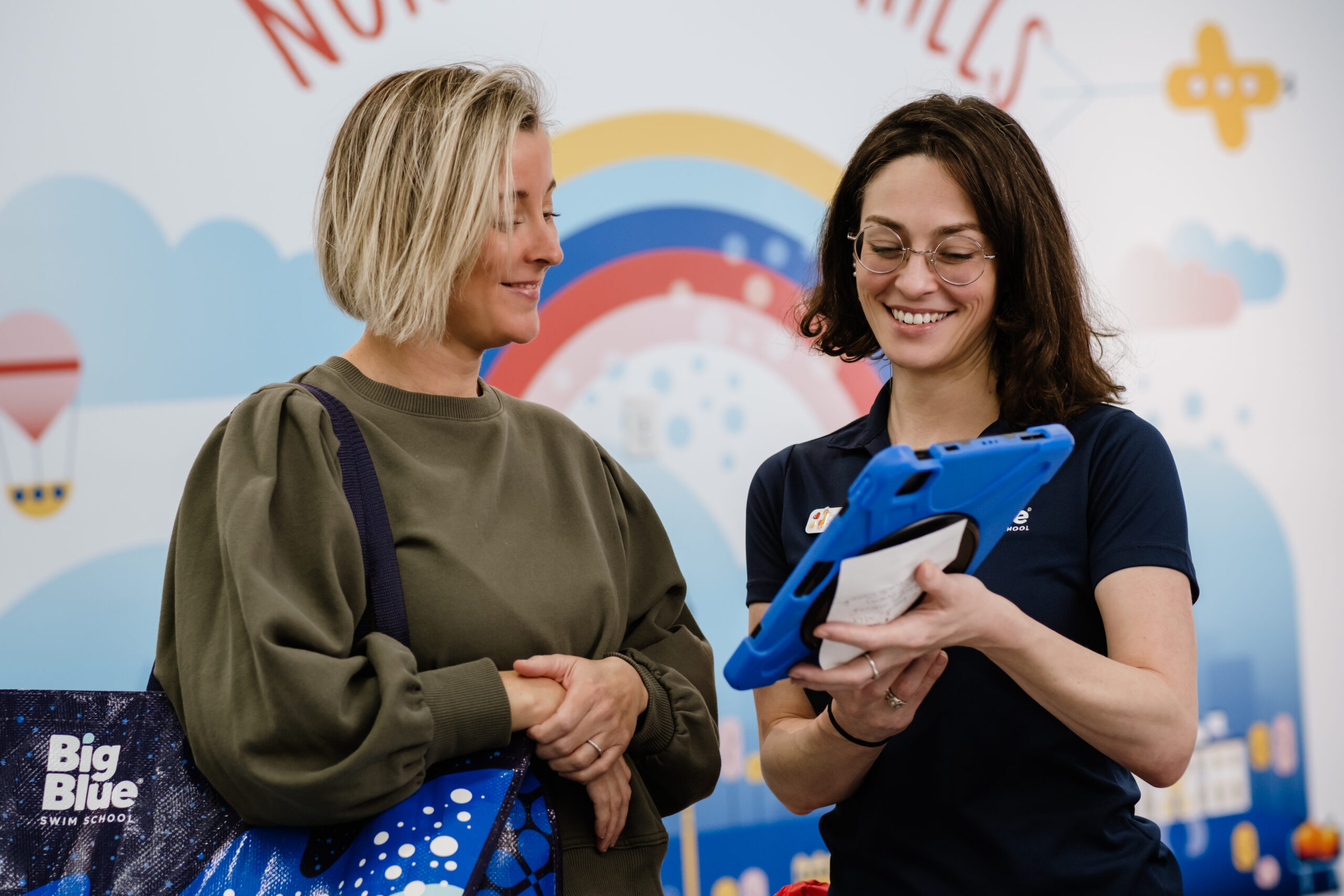 big blue staff member helping a mom to schedule lessons